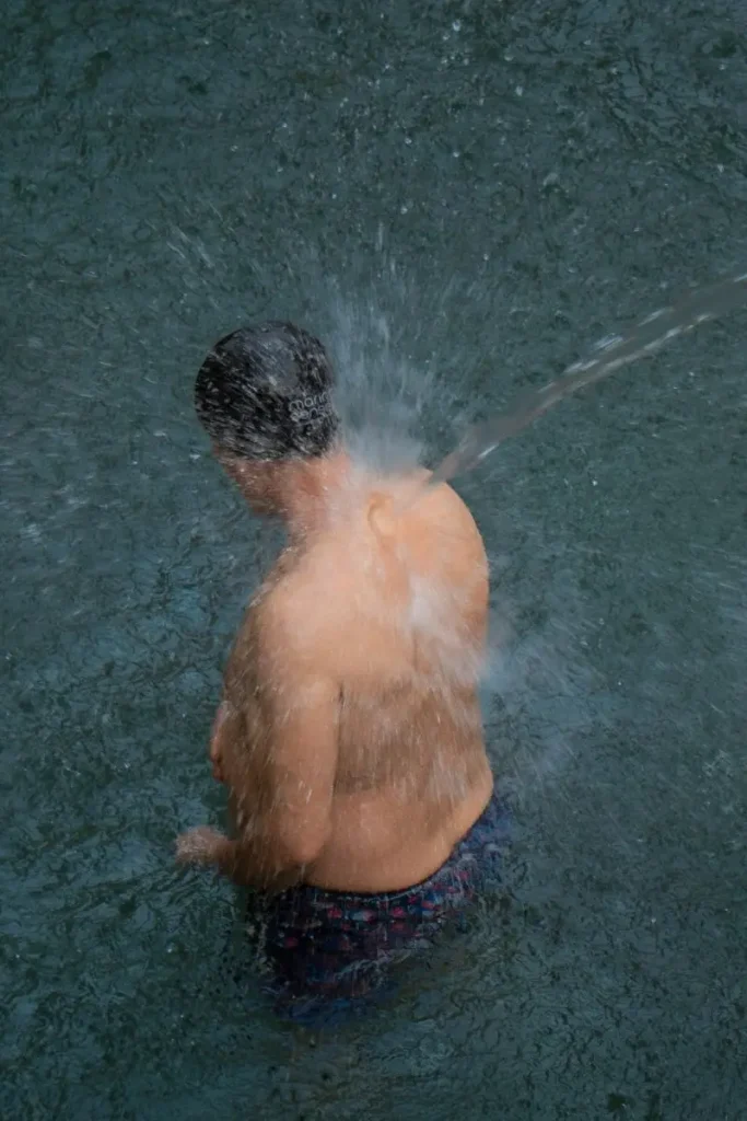 Vista de una persona disfrutando de baños termales en verano en el Balneario de la Virgen